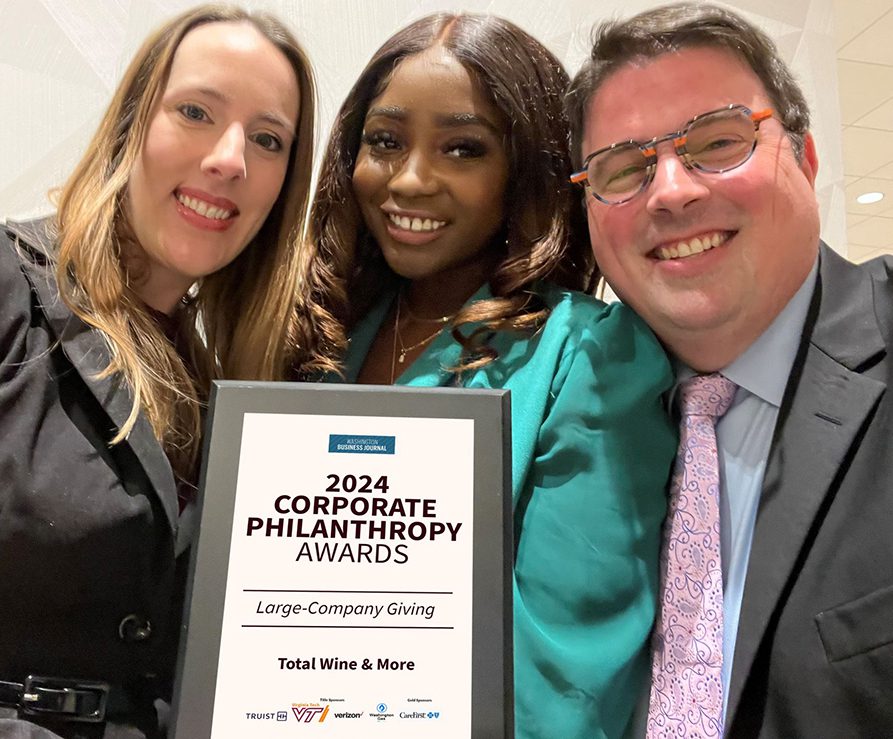 Three Total Wine team members smiling and holding up a 2024 Corporate Philanthropy award.